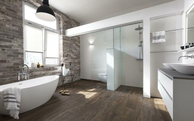 Badezimmer mit Backsteinwand und weißer Ausstattung